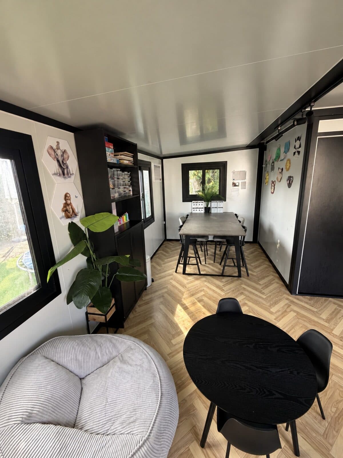Onze ruimte in Kudelstaart, met een zitzak, een ronde tafel en de lange lunchtafel